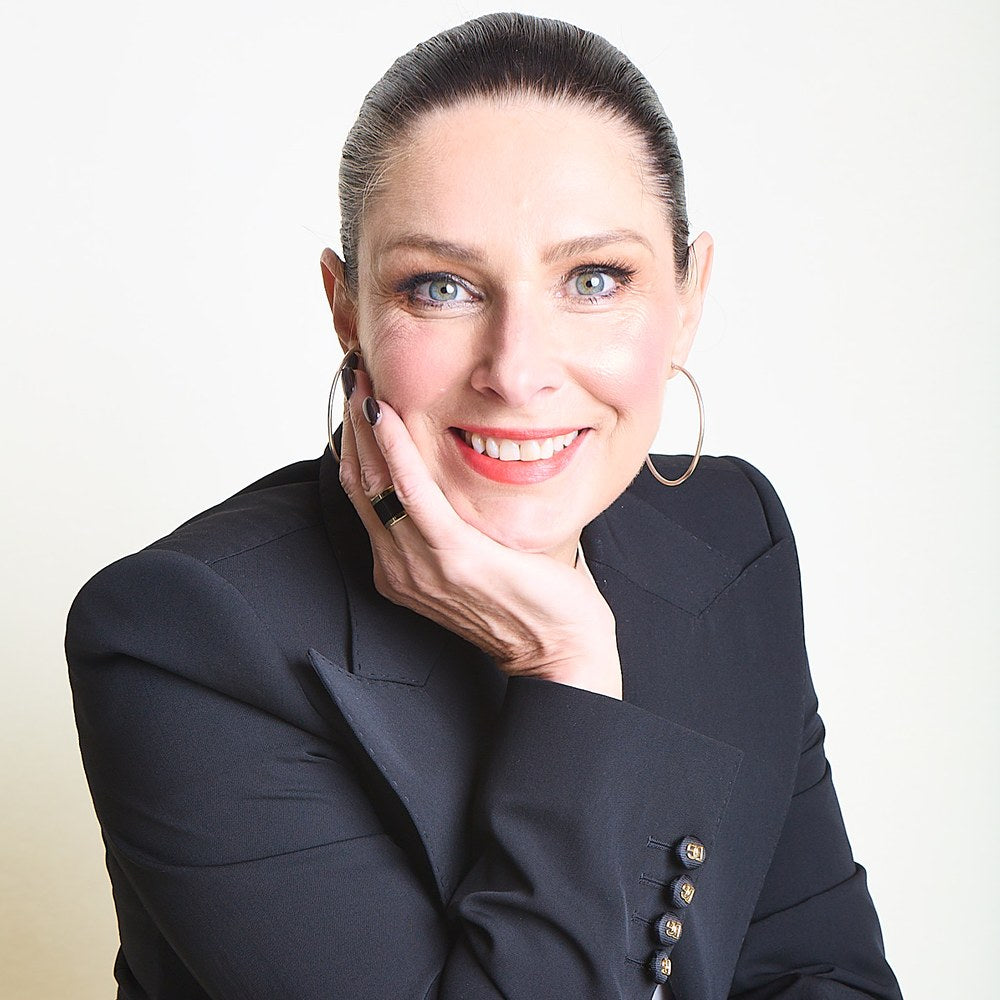 Jacqui Hutton, founder, smiling with her chin resting on her hand