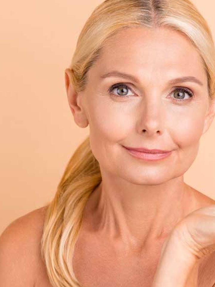 A woman holding the Fountain of Youth Elixir bottle in her palm