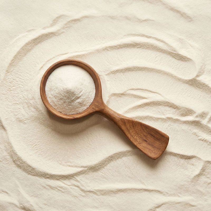 A wooden scoop of fine white tripeptide collagen powder