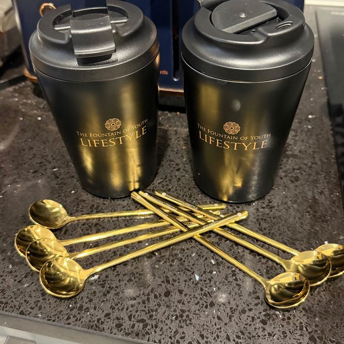 Customer photo of two Fountain of Youth Lifestyle keep cups and gold spoons