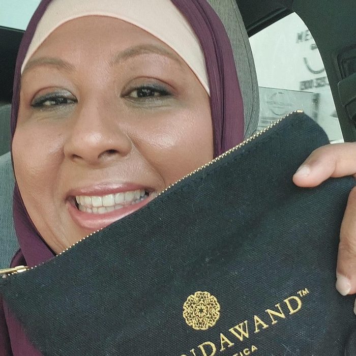 Customer holding up the GlindaWand canvas designer makeup clutch
